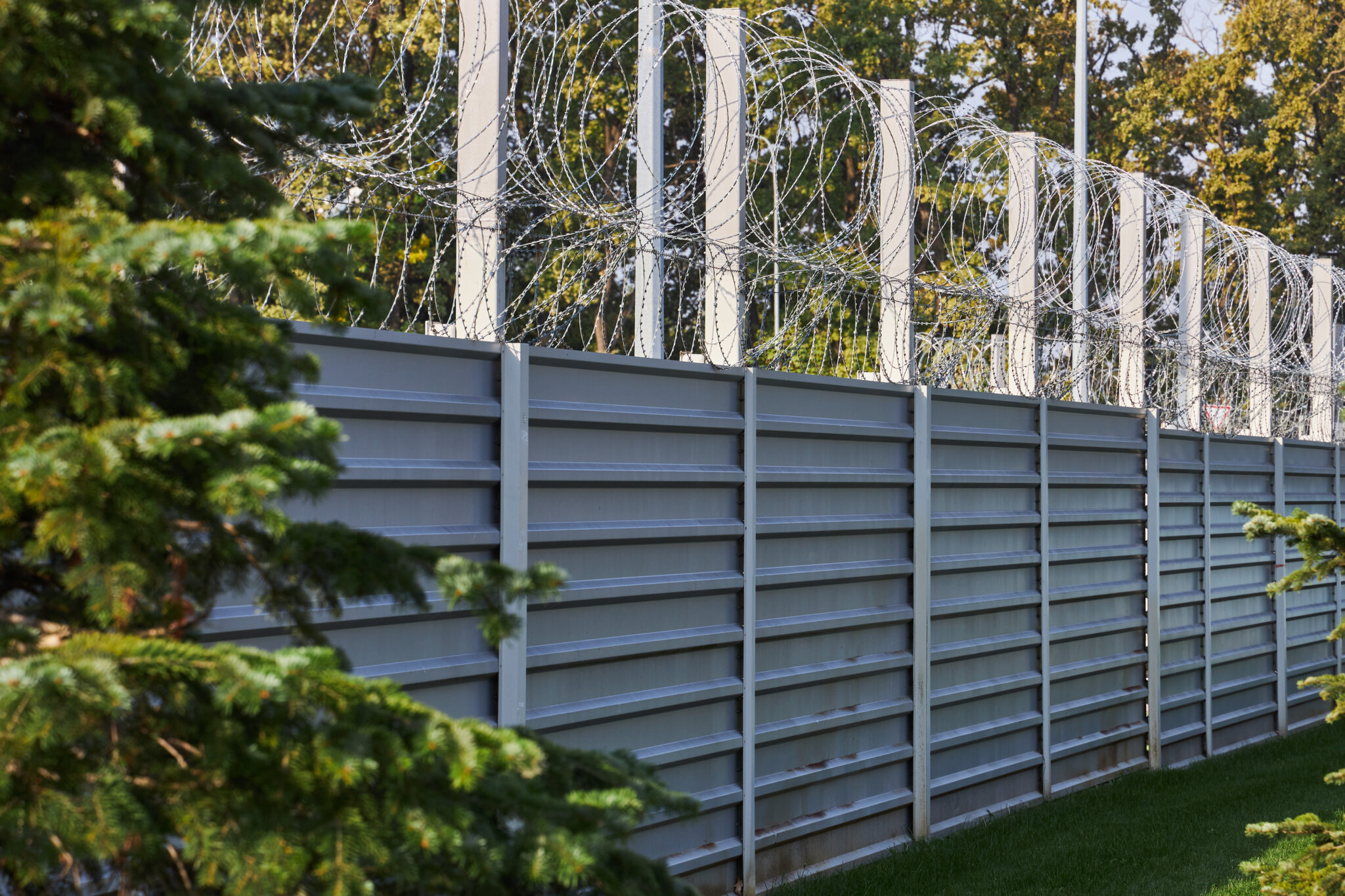 large metal fence surrounded by barbed wire